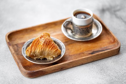Small cup of Turkish coffee and Turkish baklava on table