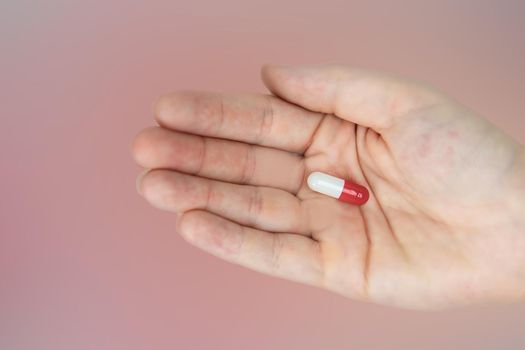 hands holding red and white capsules for medication, vitamin or drugs background on white background. Top view. Flat lay. Copy space. Close up. Medicine,business and health concept colorful