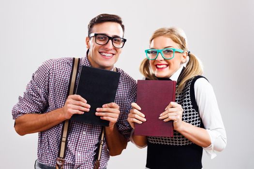 Happy nerdy man and woman holding books.