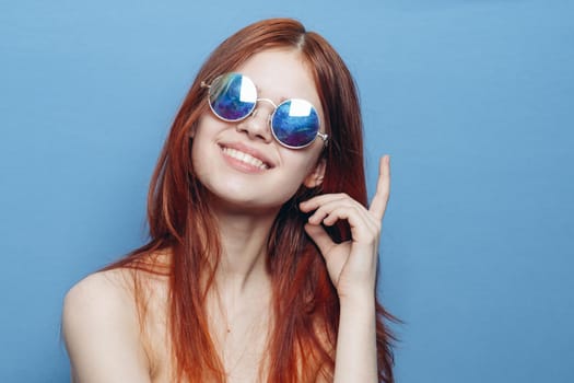 attractive woman with bare shoulders fashionable glasses blue background. High quality photo