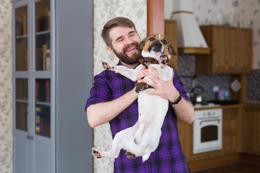 Close Up portrait handsome young hipster man loves his good friend dog at home. Positive human emotions, facial expression, feelings.