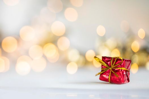 christmas present red and silver baubles against bokeh lights gold shiny glitter background with copy space, space for text