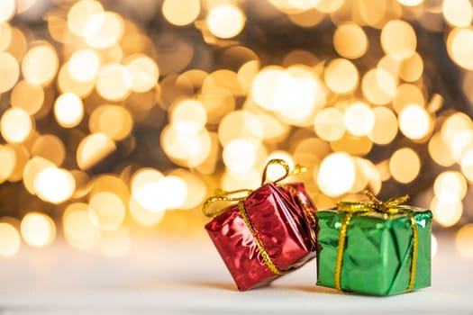christmas present red and silver baubles against bokeh lights gold shiny glitter background with copy space, space for text