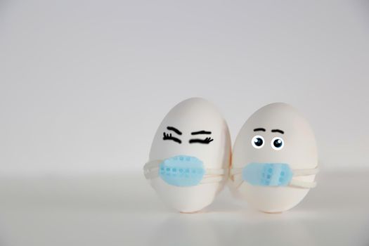 Easter eggs with Corona virus COVID19 protection concepts. DIY Do It Yourself easter eggs wearing mask for Easter holidays decoration on white background Selective focus with copy space. COVID-19 protection coronavirus