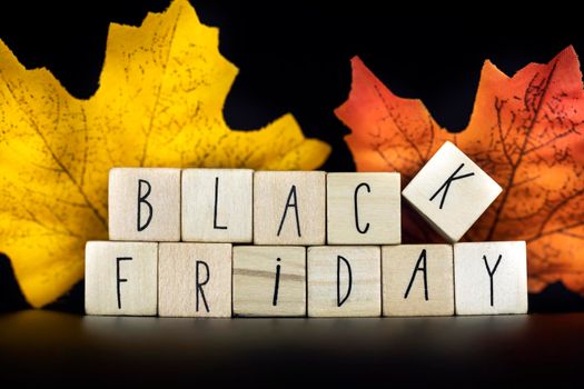 Sale and Blackfriday concept text with autumn discount sale,Seasonal Offer on black background with colorful autumn leafs closeup