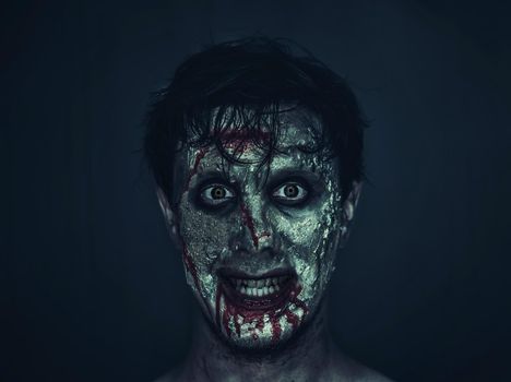 Portrait of funny zombie man in blood. Halloween or horror theme