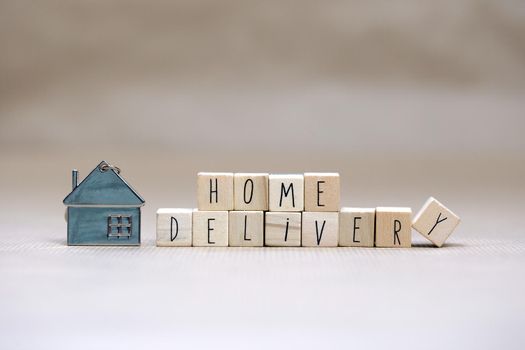 Home delivery text with wooden cubes and little miniature house on blurred background, Business, stay home for Covid-19, we deliver concept background copy space