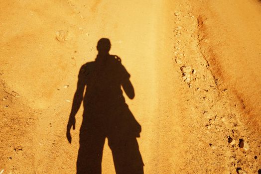 Man takes photographs his shadow on ground
