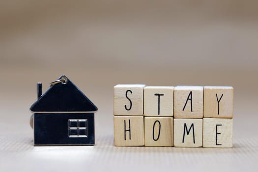 Stay home written with wooden cubes and miniature house, Covid-19, health stay at home. Quarantine concept. background copy space text