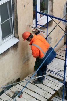 Saint Petersburg, Russia - April 24, 2021: Workers erect scaffolding to repair the facade of a building