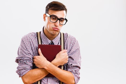 Portrait of Exhausted nerd student holding book.