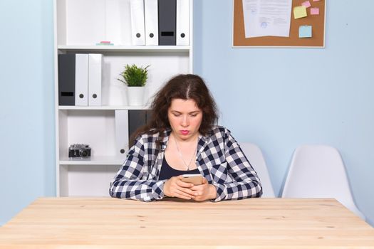 Portrait of business girl sitting on table in office