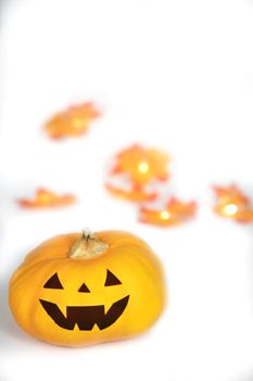 Halloween Jack O Lantern with autumn foliage isolated on white background, Pumpkin head on coloful leaves, spooky smile with copy space space for text