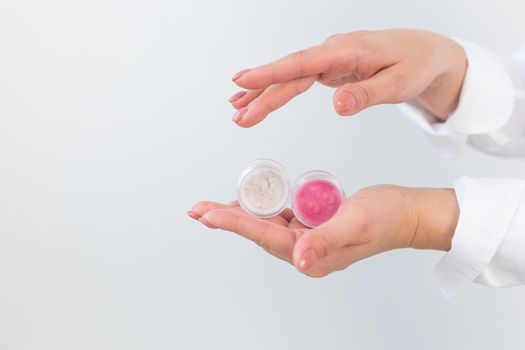 Woman hand holding loose beige powder on a white background. Isolated background. Space for text