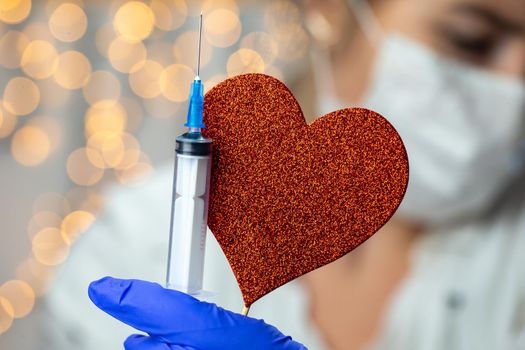 Doctor, nurse, scientist, researcher hand in blue gloves holding flu, measles, coronavirus, covid-19 vaccine disease preparing for human clinical trials vaccination shot,with heart symbol health concept