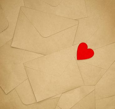 Brown various envelopes with red heart background. Happy Valentines day concept. Top view, copy space romantic design