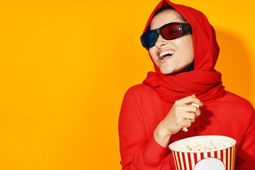 arab woman 3d glasses technology watching movie popcorn yellow background. High quality photo
