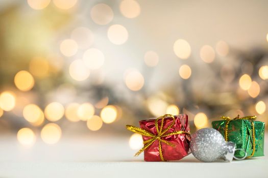 christmas present red and silver baubles against bokeh lights gold shiny glitter background with copy space, space for text