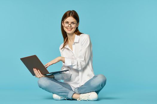 woman with laptop learning internet online education blue background. High quality photo