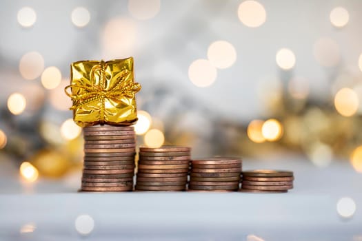 Coin climbing stairs with Christmas Holiday present, sparkling and shiny background, Finance,saving concept stacks of coins copy space