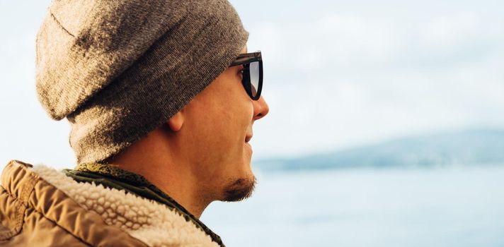 Portrait of hipster handsome young man on background of sea