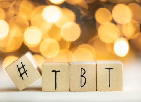 Hashtag TBT throwback Thursday written with wooden cubes with shiny bokeh background, social media concept colorful