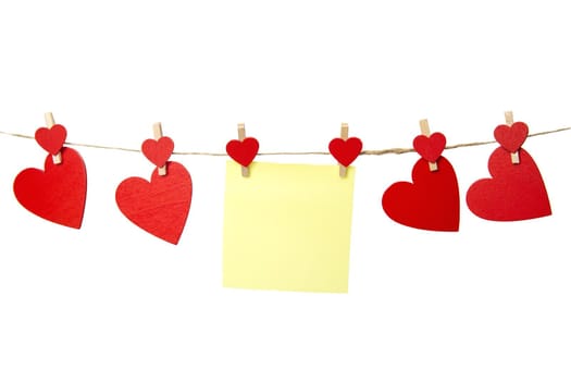 Blank yellow sticky note hanging with red hearts isolated on white background, romantic Valentines Day concept, copy space. Space for text