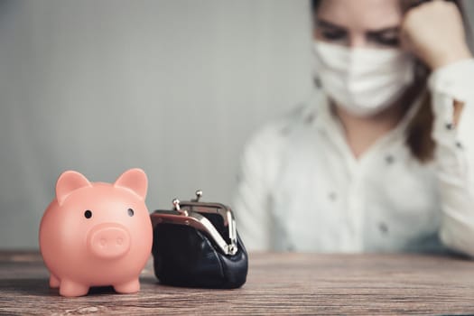 Young Female business woman with pink piggy bank for savings and wearing safety mask for Covid-19, depressed,financial,business,lockdown concept background debts