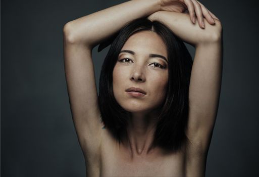 Portrait of attractive mixed race woman with beauty makeup and hairstyle on dark background
