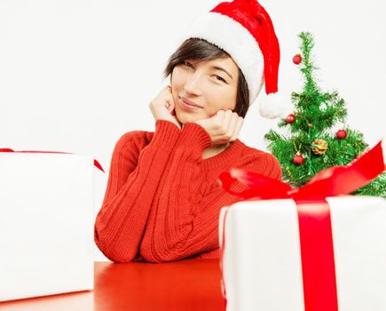 Happy young woman sits on the background of the Christmas tree
