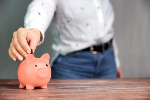 Piggy bank saving currency, person putting coin in for saving money, business, financial, savings and tax concept with copy space space for text