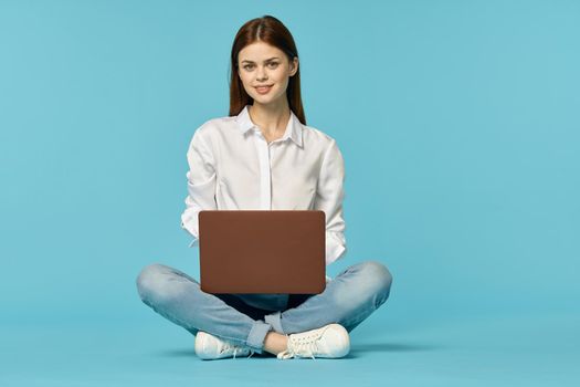 woman with laptop learning internet online education blue background. High quality photo