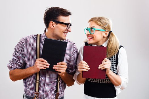 Happy nerdy man and woman holding books.