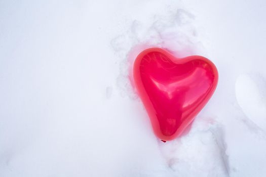 Beautiful red heart balloon for Valentines Day in the fresh white snow background, copy space, Valentine,winter,love concept space for text