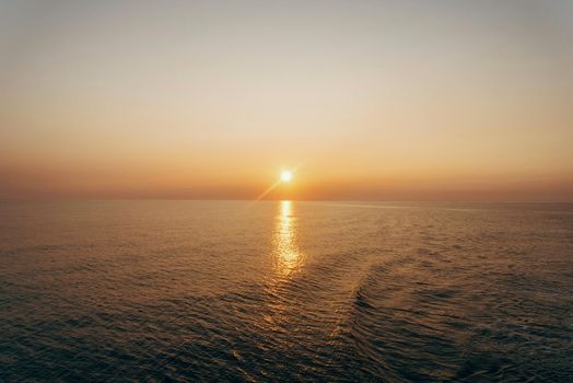 Beautiful sunset over the sea with light reflection on water surface