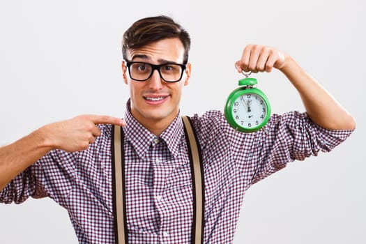 Portrait of nerdy man pointing at  clock.