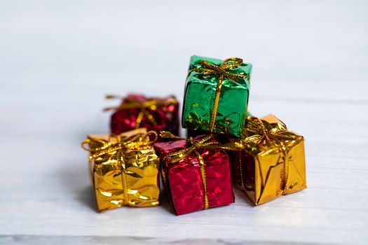 Pile of colored shiny gift boxes with copy space on white wood background,modern retro Christmas design, Colorful presents,Holiday concept space for text
