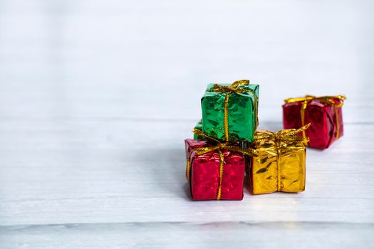 Pile of colored shiny gift boxes with copy space on white wood background,modern retro Christmas design, Colorful presents,Holiday concept space for text