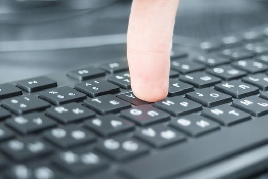 Pressing the keyboard closeup. Black keyboard on the desk