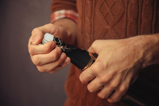 Man is opening the champagne, close-up, vintage style