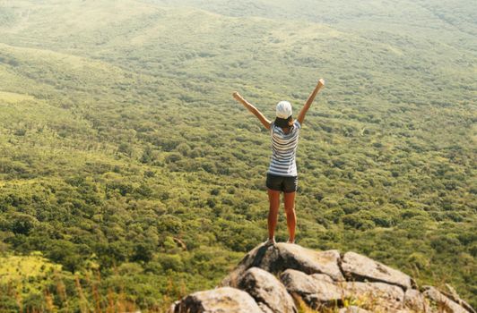 Freedom hiker woman in nature on mountain with raised arms enjoying happiness in beautiful landscape