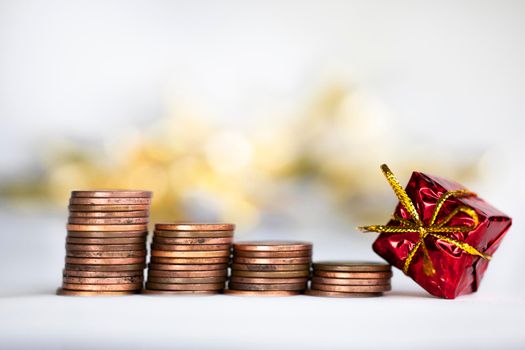 Coin climbing stairs with Christmas Holiday present, sparkling and shiny background, Finance,saving concept stacks of coins copy space