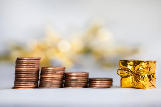 Coin climbing stairs with Christmas Holiday present, sparkling and shiny background, Finance,saving concept stacks of coins copy space