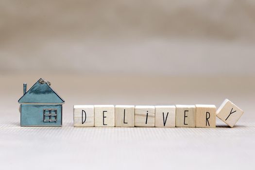 Home delivery text with wooden cubes and little miniature house on blurred background, Business, stay home for Covid-19, we deliver concept background copy space