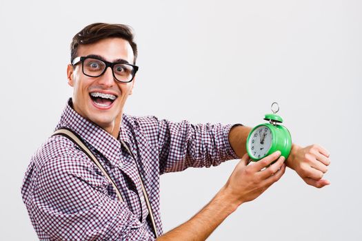 Portrait of happy  nerdy man holding clock.