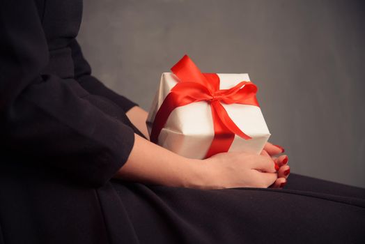 Unrecognizable woman in dress is holding a present, side view