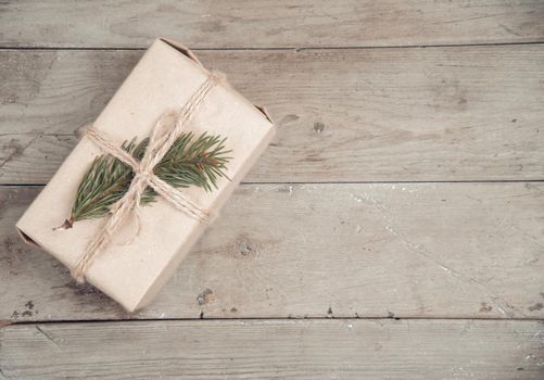 Vintage gift box with Christmas tree branch on a wooden table, copyspace