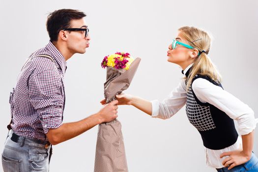 Romantic nerdy man   is giving flowers to his nerdy  girlfriend.