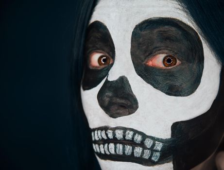 Scary skull woman looks at camera, Halloween makeup