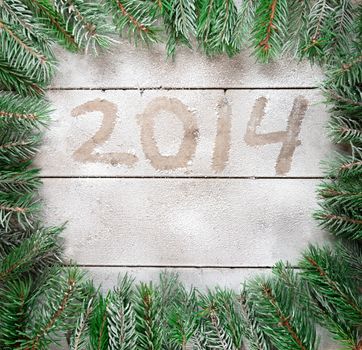 Branches of Christmas tree around the inscription 2014 in the snow